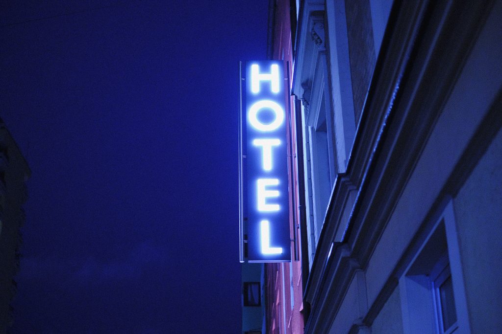 Néon bleu "Hotel" sur la façade d'un immeuble