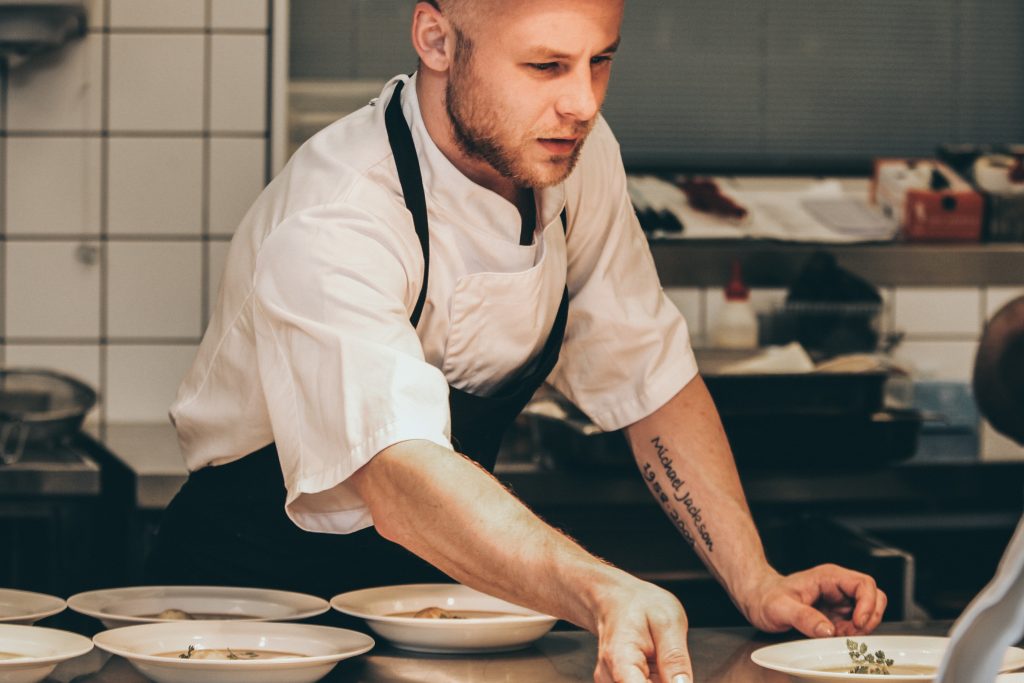 Cuisinier qui prépare des assiettes en cuisine